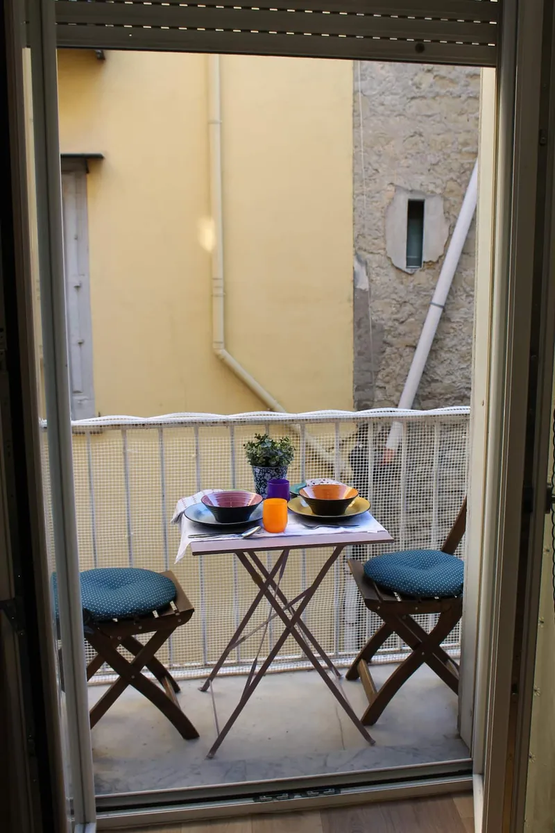 The table laid on the balcony, seen from the French window.