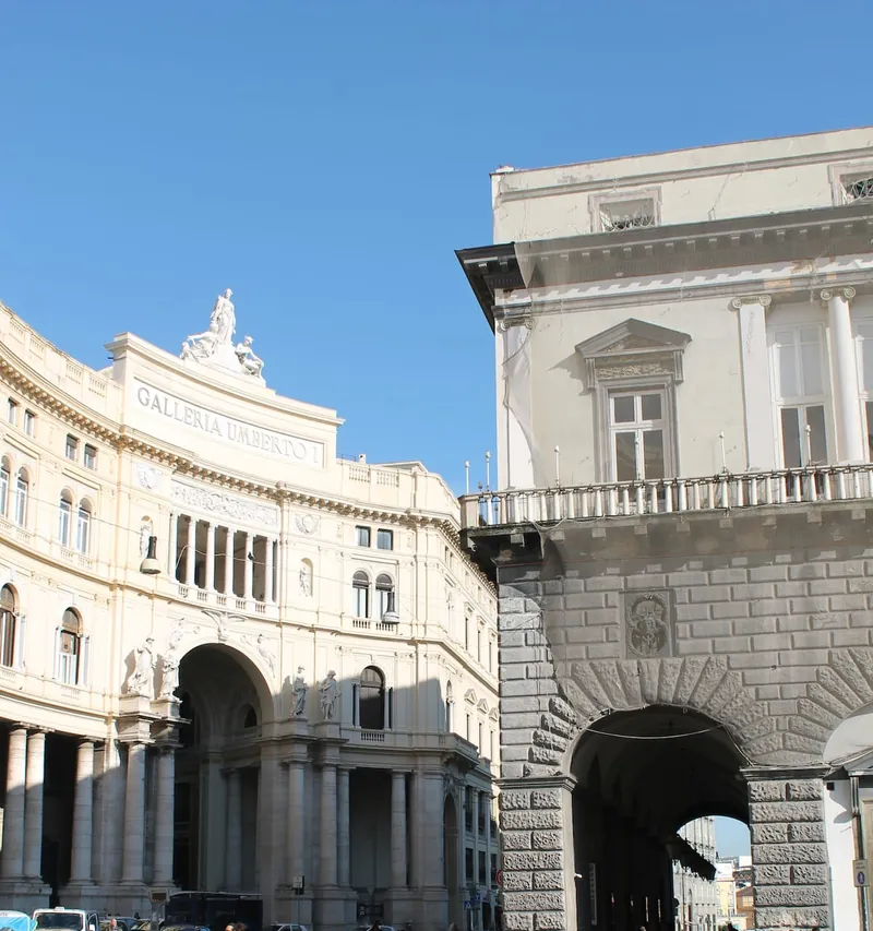 The Galleria Umberto I from outside, with the lettering on its façade and a blue sky.