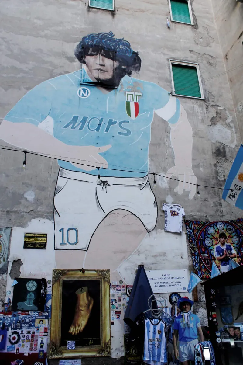 The mural of Diego Armando Maradona in Napoli’s sky-blue shirt, painted on the side of a building.