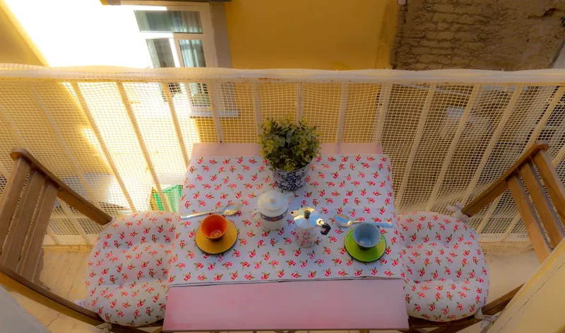 The balcony table from above, with colourful cups and the sugar bowl.